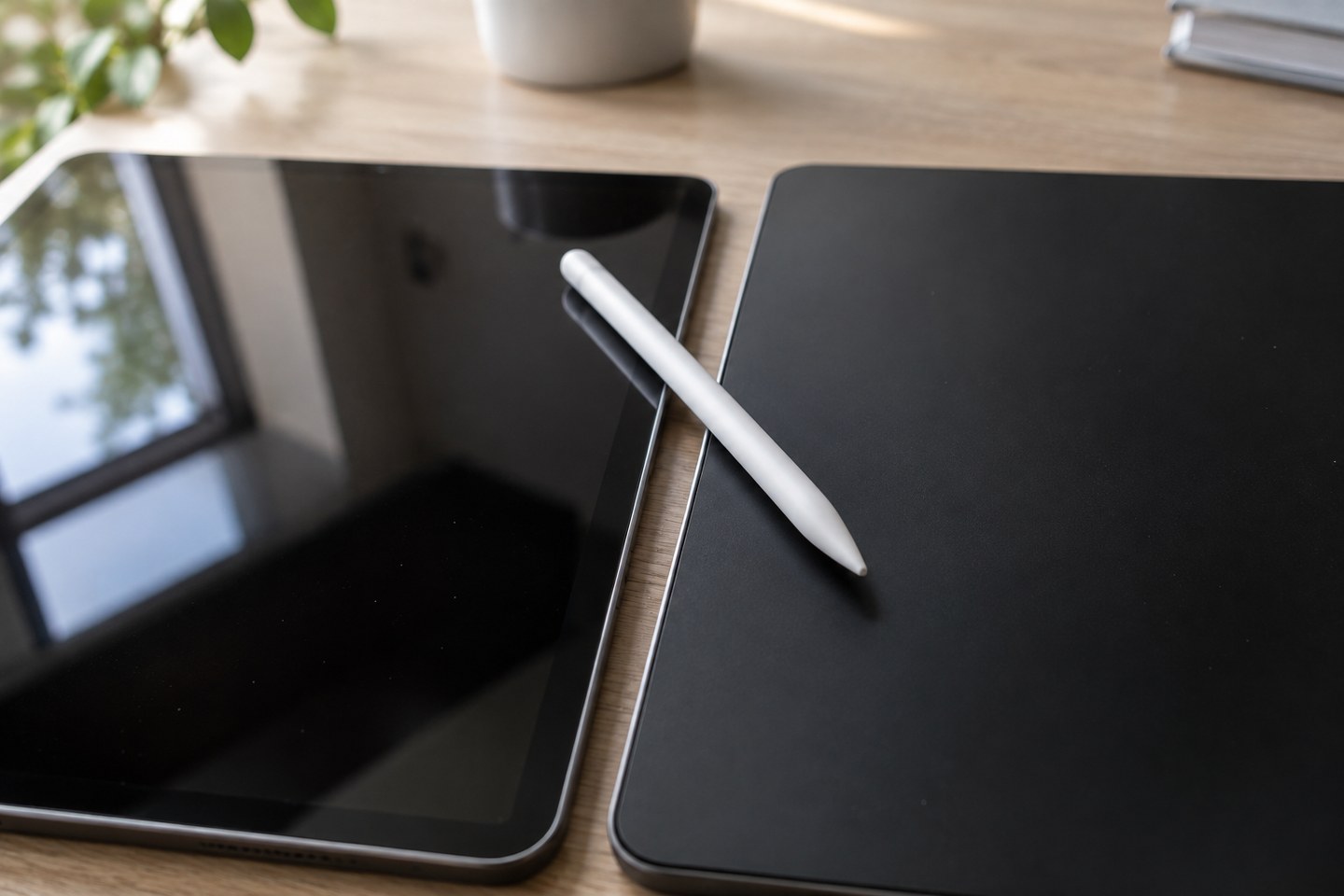 Détail de deux dalles de tablette côte à côte, l'une brillante qui reflète la fenêtre, l'autre mate